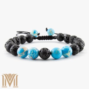 May include: Adjustable bracelet with black lava rock beads and turquoise jasper beads. The bracelet has a black cord and two turquoise accent beads. The bracelet is designed to be worn on the wrist.