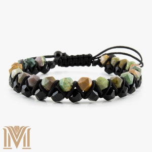 May include: A bracelet with multi-coloured faceted gemstones and black onyx beads, strung on black cord. The bracelet has an adjustable closure. The gemstones are in shades of green, brown, and purple. The bracelet is approximately 18 cm in length.