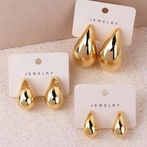 以下が含まれることがあります： 白いカードに「JEWELRY」と印刷された、3組のゴールドの涙型イヤリング