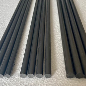 May include: A set of ten black carbon fiber rods, each approximately 12 inches long, with rounded ends. The rods are arranged in five rows of two, with the ends of the rods aligned.