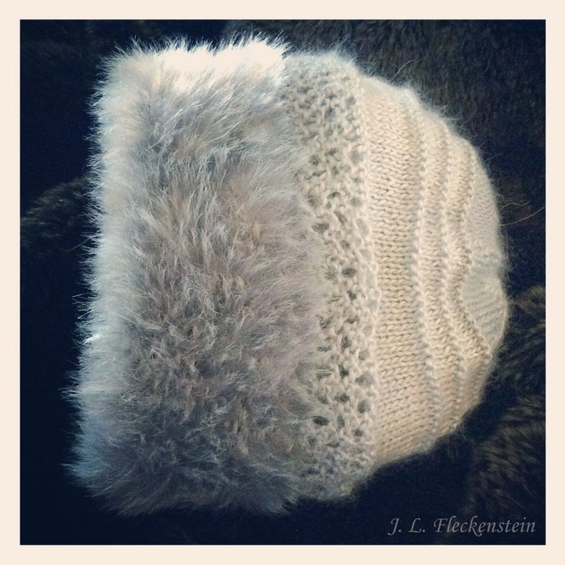 May include: A white knitted hat with a fluffy gray fur trim. The hat has a simple design with vertical stripes and a delicate lace pattern.