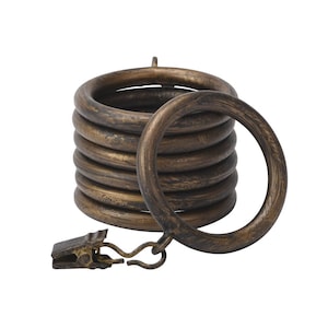 May include: A set of eight antique gold curtain rings with a clip for hanging curtains. The rings are stacked on top of each other and have a distressed finish.