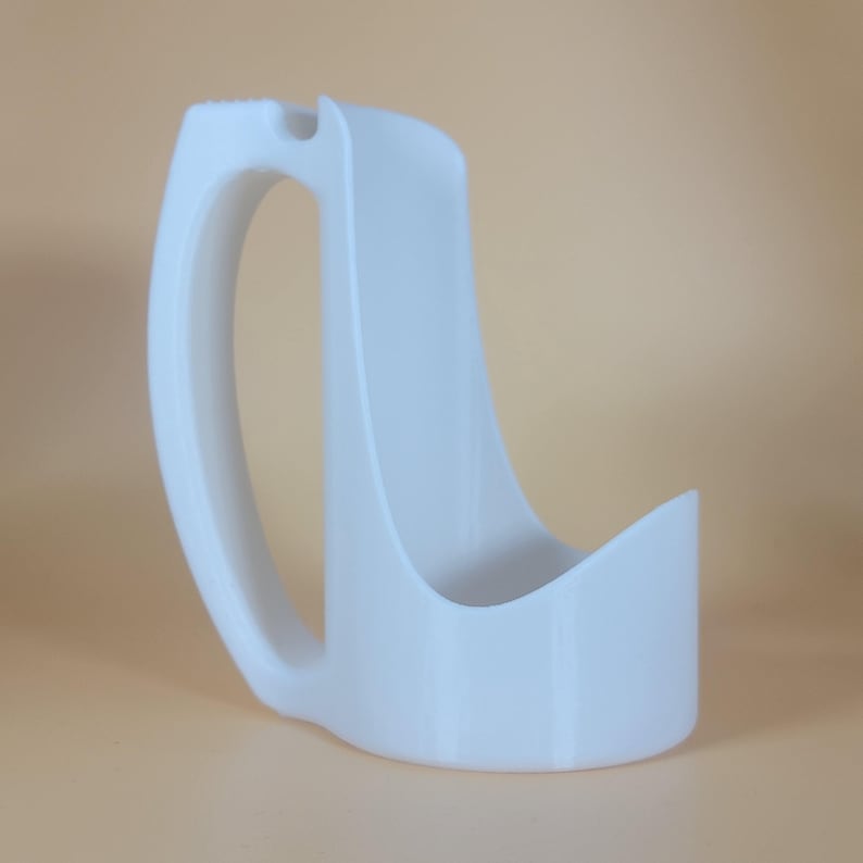 May include: White plastic 3D printed mug with a handle. The mug has a unique design with a curved lip and a wide base.