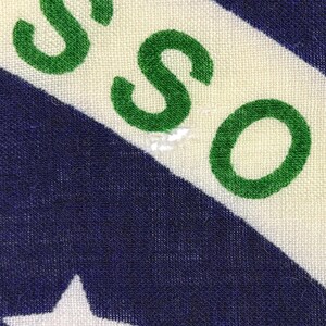 Pode incluir: Close-up de um tecido com um padr&atilde;o repetitivo. O design apresenta letras verdes que soletram "SO" em um fundo branco, com listras diagonais azuis e brancas e estrelas brancas.