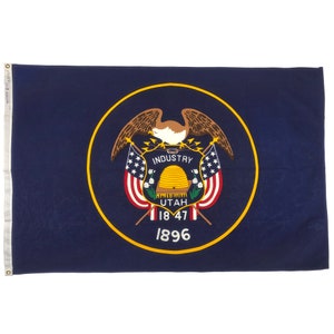 May include: A navy blue Utah state flag with a gold-bordered emblem featuring an eagle, beehive, and the words "INDUSTRY" and "UTAH". The flag also displays the years 1847 and 1896.