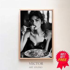 Könnte beinhalten: Schwarzweißfoto einer Frau, die Spaghetti isst. Sie trägt ein schwarzes Spitzenoberteil und hat ihre Haare nach hinten gebunden. Das Foto ist in einem Holzrahmen gerahmt.