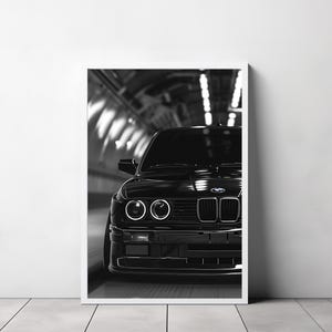 May include: A black and white photograph of a black BMW E30 driving through a tunnel. The car is in focus, and the tunnel is blurred in the background.