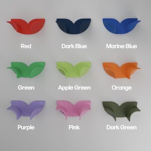 May include: A grid of nine curved, wing-shaped silicone holders in various colors, each labeled with its corresponding color name: Red, Dark Blue, Marine Blue, Green, Apple Green, Orange, Purple, Pink, and Dark Green, arranged in three rows.