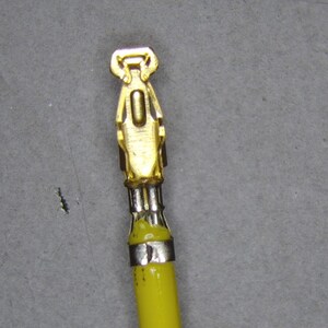 May include: A gold-colored electrical connector with a yellow wire attached.