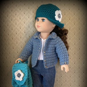 May include: A doll wearing a teal crochet hat with a white flower, a blue crochet jacket, denim trousers, and teal crochet shoes. The doll holds a teal backpack with a white flower. The text "Restyled-Junk" is in the bottom right corner.