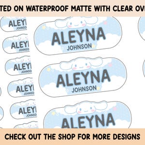 May include: A set of 10 personalised iron-on labels featuring a cartoon dog with a blue cloud background. The labels say "ALEYNA JOHNSON" in black text. The labels are printed on waterproof matte material with a clear overlay.