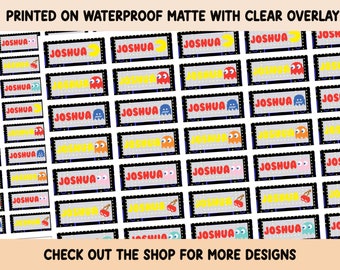 May include: A sheet of waterproof matte stickers with a clear overlay. The stickers feature a Pac-Man inspired design with the name "Joshua" printed on each sticker.