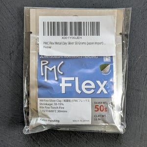 May include: A package of PMC Flex Metal Clay Silver, 50 grams, with text including "999 Fine Silver Clay" and "Made in Japan." The package is sealed in clear plastic and has a white label with a barcode.