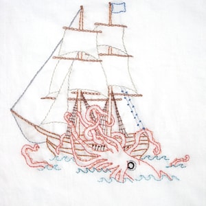 May include: Embroidered artwork depicting a brown sailing ship with a blue flag being attacked by a pink and red octopus with one large black eye. The ship is surrounded by blue waves.