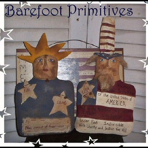 May include: Two folk art figures, one with a star-shaped crown and the other with a striped hat. The figures are painted with patriotic themes, including the text "USA" and "of the United States of AMERICA". The words "Barefoot Primitives" are at the top.
