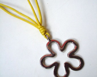 Silver flower pendant on a yellow cord