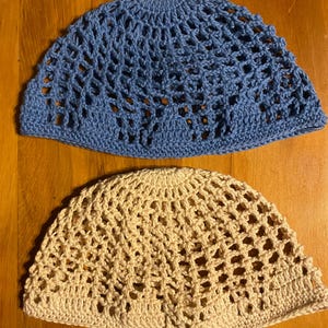 May include: Two crocheted hats, one blue and one beige, with a lacy pattern. The hats are made of a soft, lightweight yarn and have a comfortable fit.