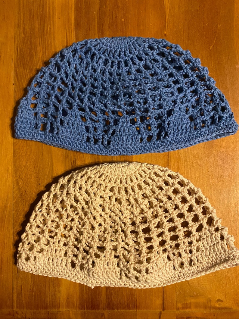 May include: Two crocheted hats, one blue and one beige, with a lacy pattern. The hats are made of a soft, lightweight yarn and have a comfortable fit.