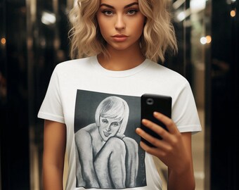 Puede incluir: Una mujer con una camiseta blanca con una ilustración en blanco y negro de una mujer. Ella sostiene un teléfono inteligente negro en su mano derecha. Ella está de pie en un pasillo con paredes de espejo.
