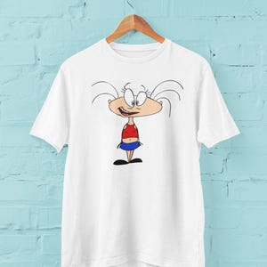 May include: White t-shirt with a cartoon illustration of a girl with white hair, a red top, and a blue skirt.
