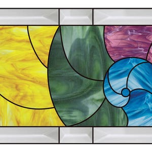 May include: Stained glass panel with a geometric design. The panel features sections of brown, yellow, green, purple, and blue glass, each with a swirling pattern. The glass is framed by a white border with black lines.