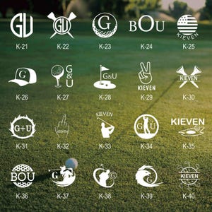 May include: A collection of white golf-themed designs on a green background. The designs include initials, golf balls, flags, and the American flag. Each design is labeled with a "K" followed by a number, such as "K-21".