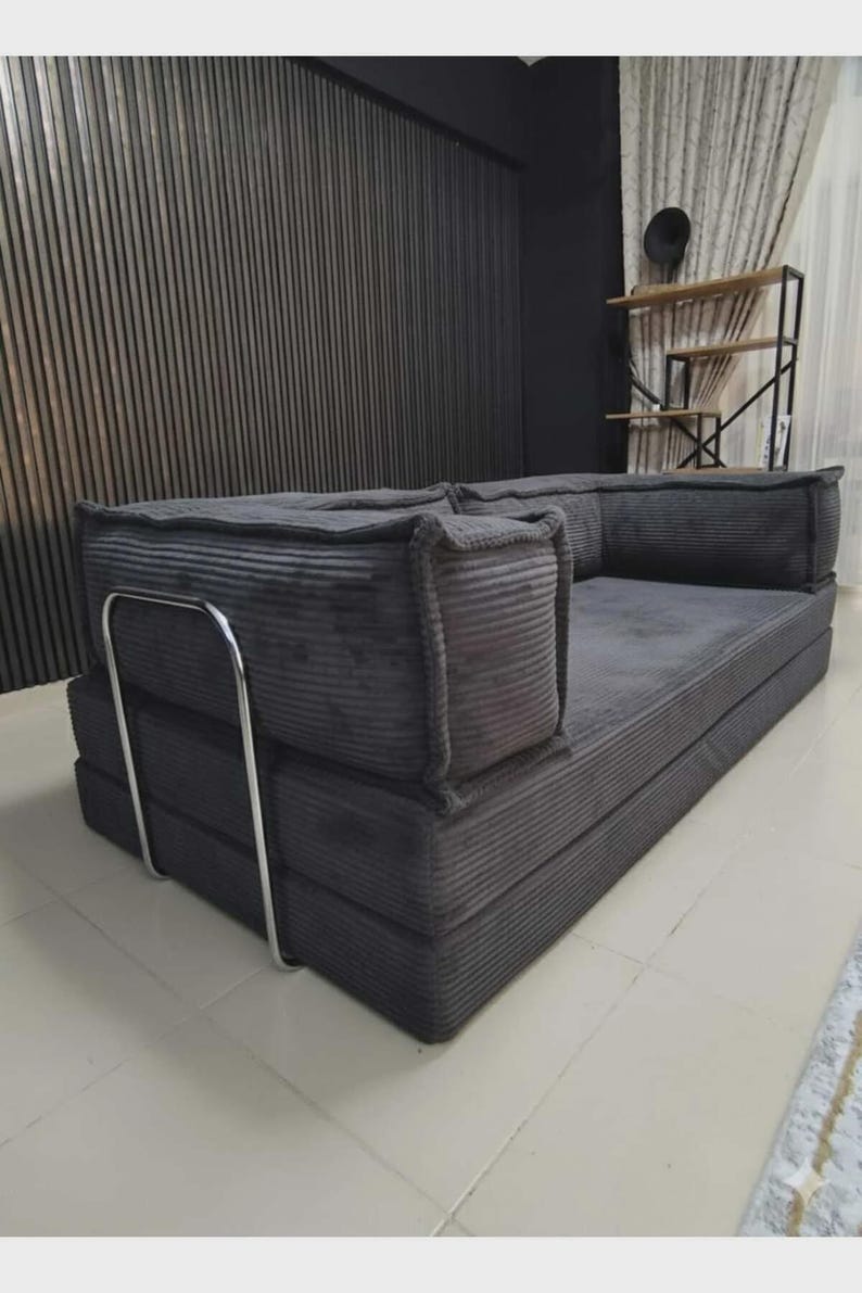 Peut inclure: Un canap&eacute; en velours c&ocirc;tel&eacute; gris avec un design modulaire. Le canap&eacute; a un profil bas et une esth&eacute;tique simple et moderne. Il est dot&eacute; d'un cadre en m&eacute;tal et convient &agrave; un salon ou un coin salon.