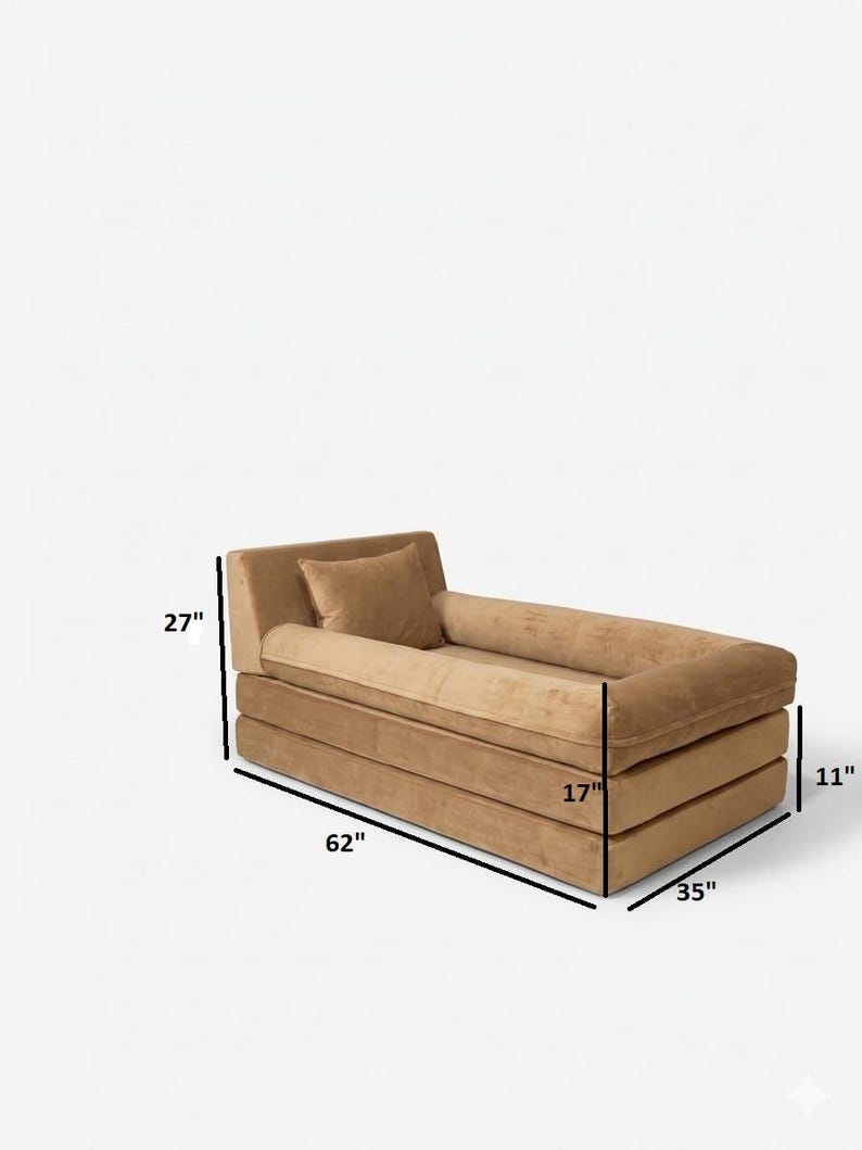 May include: A modern, tan-colored chaise lounge with a rectangular design. The lounge measures 62 inches long, 35 inches wide, and 27 inches high. It includes a small pillow and a rolled bolster. The seat is 17 inches wide and the base is 11 inches high.