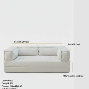 Pu&ograve; includere: Un divano moderno di colore chiaro, con una profondit&agrave; di 100 cm, una larghezza di 200 cm e un'altezza della seduta di 32 cm. Lo schienale &egrave; alto 65 cm e la profondit&agrave; della seduta &egrave; di 65 cm. Il divano ha un design minimalista.
