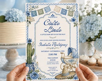 Könnte beinhalten: Eine rechteckige Babyparty-Einladungskarte mit blau-weißen Blumenrändern, einem Kaktus in einem gemusterten Topf, einem Vintage-Kinderwagen und einem Strohhut. Der Text lautet Cielito Lindo, A Little Baby Boy Is On The Way, Isabella Rodriguez, Saturday November 14 2026, 2:00 PM, The Garden House, 123 Magnolia Lane, Austin, Texas 78704, RSVP by November 1, Sofia 555-874-2196.