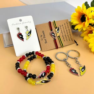 May include: Two matching friendship bracelets with black and yellow beads, a pair of earrings with a broken heart design, and a matching set of keychains with a broken heart design. The text on the card reads "For My Best Friends".