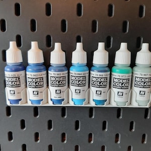 May include: A set of ten small bottles of acrylic paint in various shades of blue and green. The bottles are labelled "Model Color" and have the numbers 70.925, 70.962, 70.965, 70.844, 70.966, 70.973, and 70.907 printed on them.
