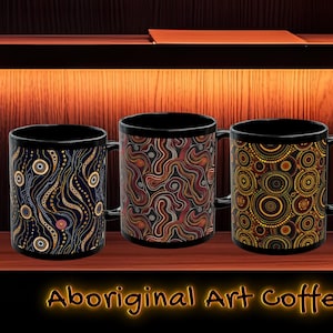 May include: Four black coffee mugs with Aboriginal art designs. Each mug features a unique pattern in shades of blue, brown, orange, and yellow. The mugs are displayed on a wooden shelf with the text "Aboriginal Art Coffee Mugs".