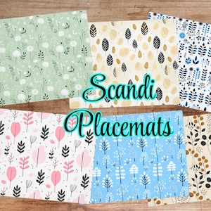 Könnte beinhalten: Eine Sammlung von Scandi-Tischsets mit verschiedenen Blumen- und Blättermustern in Pastellfarben. Die Tischsets zeigen Designs in Grün, Rosa, Blau und Beige mit schwarzen und weißen Akzenten. Der Text "Scandi Placemats" ist zu sehen.