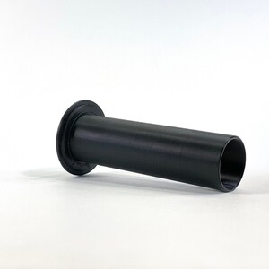 May include: A black plastic pipe with a round opening at one end and a flat edge at the other end.