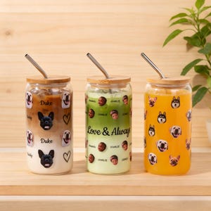 Puede incluir: Tres vasos de vidrio con tapas de bamb&uacute; y pajitas de metal. Cada vaso presenta una bebida diferente y est&aacute; decorado con caras de perros y nombres. Un vaso tiene el texto "Love & Always".