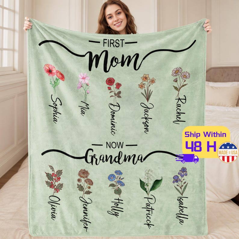 May include: A green fleece blanket with the text "First Mom Now Grandma" and floral designs. The names of children are listed below each flower.