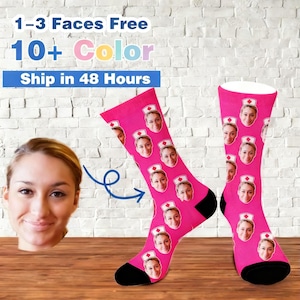 May include: A pair of pink socks featuring a repeating pattern of a person's face wearing a nurse's cap. The socks have black heels and toes. The image also includes text that reads "1-3 Faces Free" and "10+ Color".