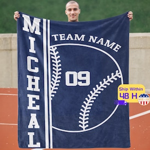 Op de afbeelding: Blauw en wit gepersonaliseerde baseball fleece deken met de naam "MICHAEL" en de tekst "TEAM NAME" en het nummer "09" op een baseball grafiek.