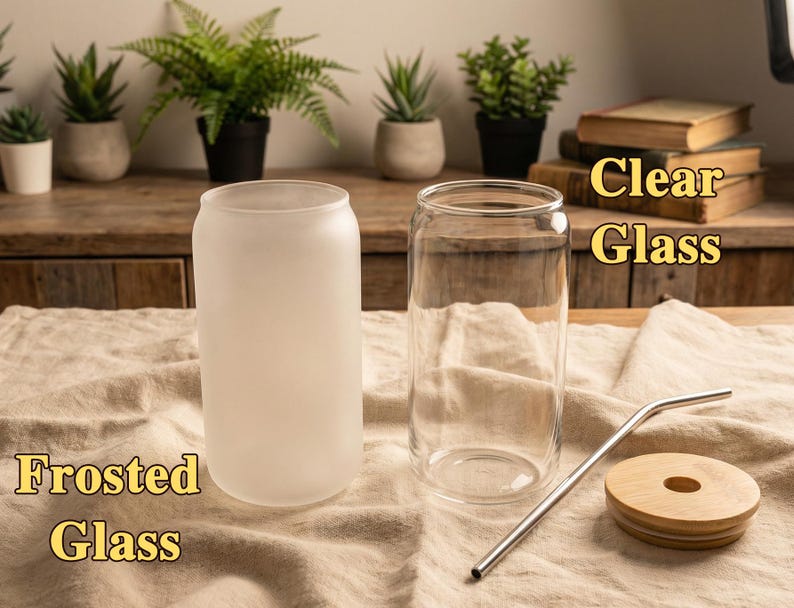 Puede incluir: Dos vasos de vidrio, uno transparente y otro esmerilado, se muestran con una pajita de metal y una tapa de madera. El texto "Clear Glass" y "Frosted Glass" tambi&eacute;n est&aacute; presente.
