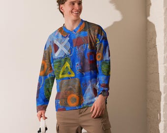 Può includere: Una maglia a maniche lunghe con base blu vivace e una stampa astratta multicolore di forme geometriche, tra cui segni X bianchi, triangoli gialli e cerchi arancioni, abbinata a pantaloni cargo color marrone chiaro con tasche laterali.