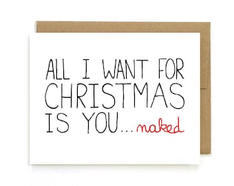 May include: A white Christmas card with the message "ALL I WANT FOR CHRISTMAS IS YOU... naked" in black, with "naked" in red. The card is presented in a brown envelope.