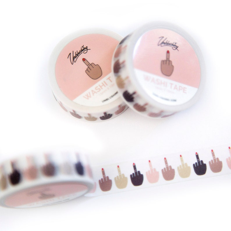 Pode incluir: Dois rolos de fita washi rosa e branca com um design de dedo do meio. A fita tem uma variedade de tons de pele. A fita &eacute; etiquetada como "Unblushing" e "Washi Tape".