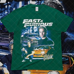 Puede incluir: Camiseta verde con el logo "Fast & Furious" e im&aacute;genes de coches y Paul Walker. El dise&ntilde;o incluye un coche plateado con rayas azules, un coche naranja y la firma de Paul Walker.