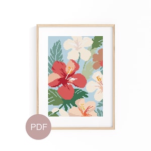 May include: A cross stitch pattern featuring a floral design with pink, red, and white hibiscus flowers and green leaves on a light blue background. The pattern is framed in a light wood frame.