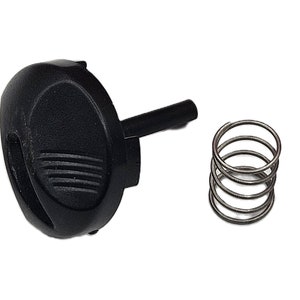 May include: A black plastic knob with a spring. The knob has a textured surface and a small hole on the side. The spring is made of metal and is coiled.
