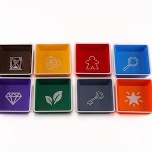 May include: Eight square plastic sorting trays arranged in two rows of four. The trays are brown, yellow, red, blue, purple, green, dark gray, and orange, each featuring a white icon: hourglass, coins, meeple, magnifying glass, diamond, leaves, key, and star.