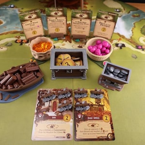 Everdell resource holders on a game board: a pouch, boat, mine cart, berry basket and a coin chest. The models have their respective tokens in them. Also on the board there are 6 open signs and 4 log shaped event card holders.