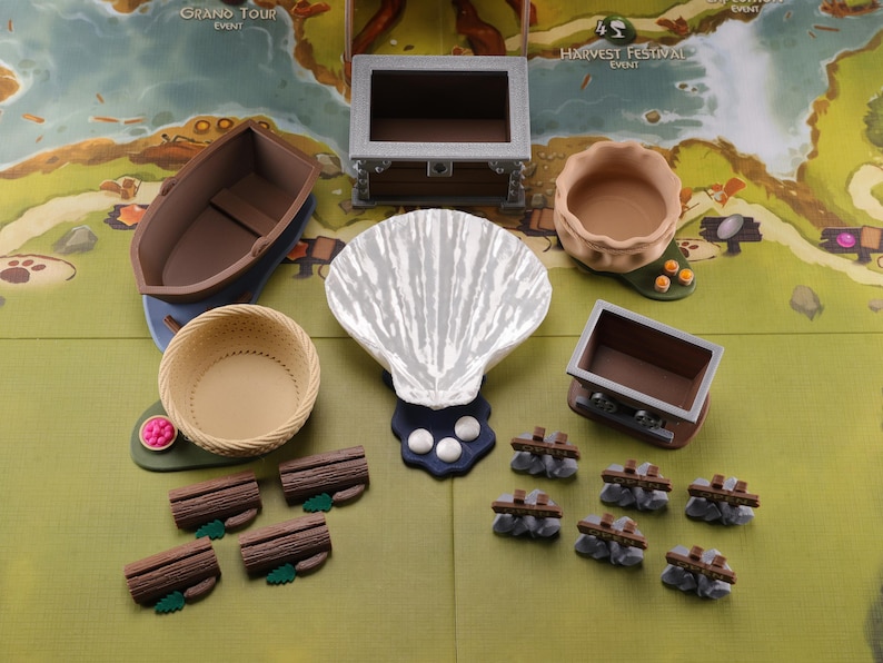Puede incluir: Un conjunto de piezas de juego de madera en miniatura para un juego de mesa. Las piezas incluyen un barco, una cesta, una concha de almeja, un cofre, un cuenco, un carro y troncos. Las piezas est&aacute;n pintadas en varios tonos de marr&oacute;n, blanco y gris.