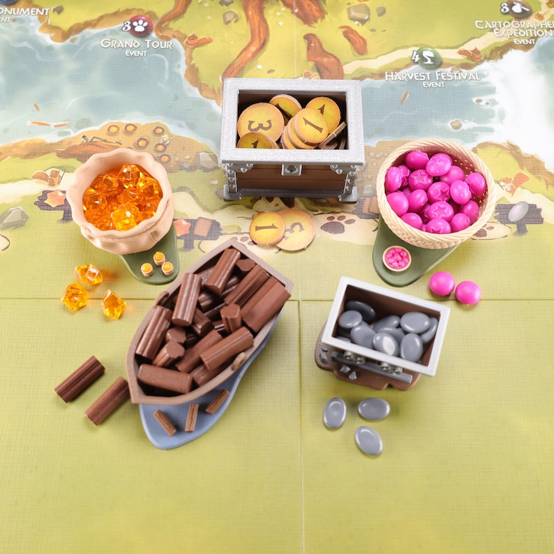 Everdell resource holders on a game board: a pouch, boat, mine cart, berry basket and a coin chest. The models have their respective tokens in them.